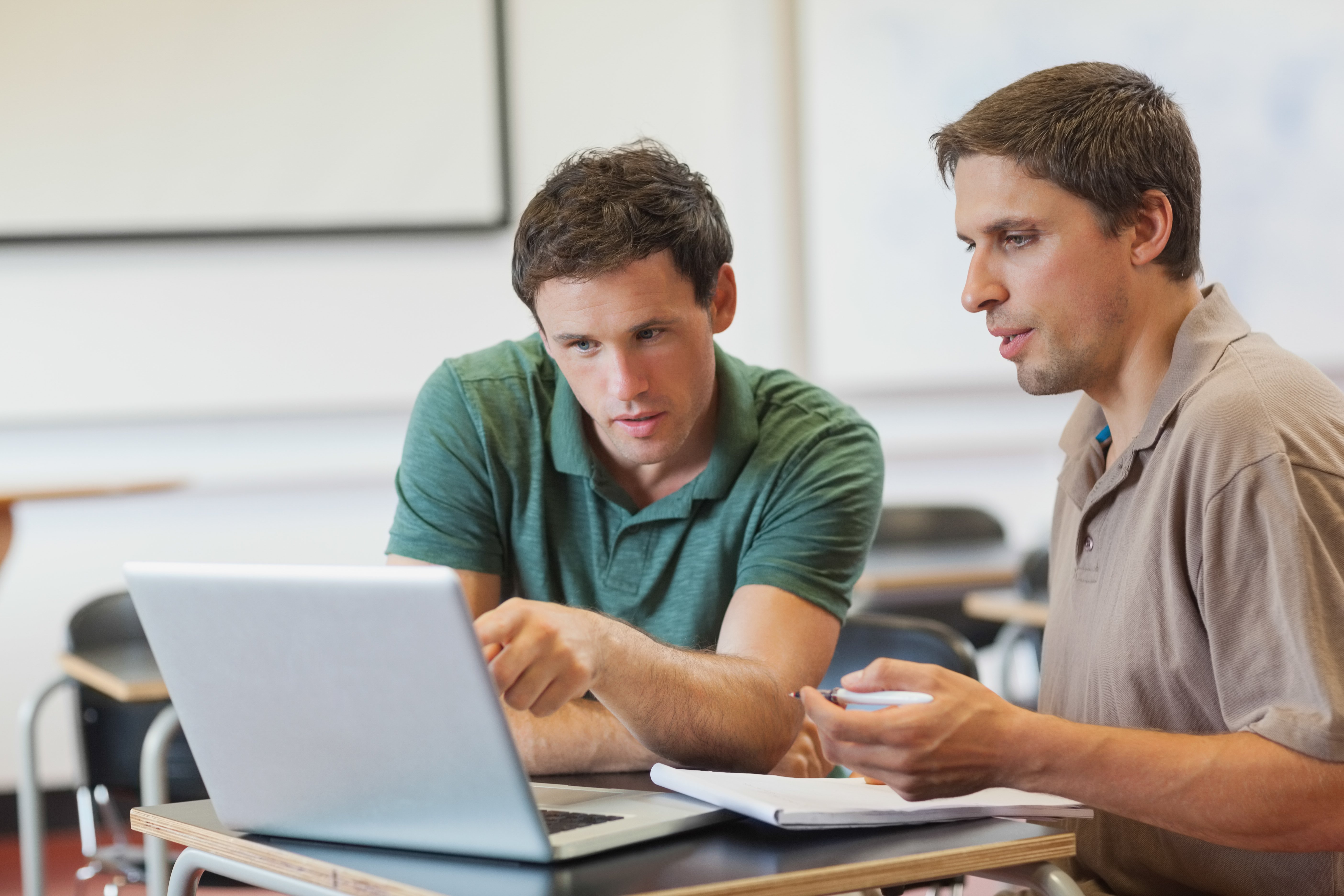 two-concentrated-handsome-mature-students-sitting-class